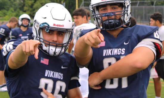 Two football players pointing at the camera.