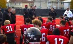 The Moore Catholic football team, known for their winning tradition, forms a formidable circle on the field as they prepare for the semifinal shutout match.