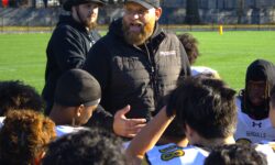 A man with a beard talking to a group of people on a field, surrounded by Sea Gulls.