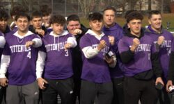 A group of men in purple shirts playing baseball in Tottenville.