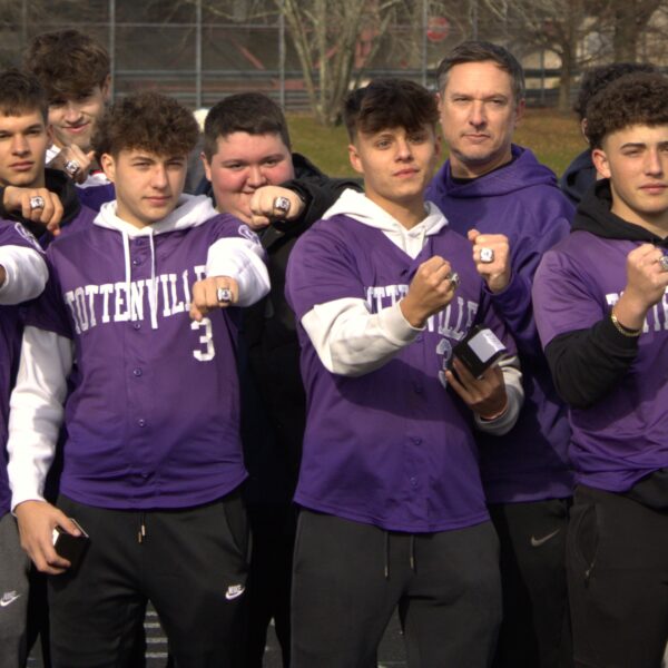 A group of men in purple shirts playing baseball in Tottenville.