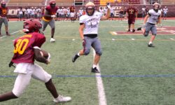 A group of CHSFL grid teams playing football on a field in Staten Island during summer practice.