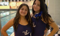 A girl in a blue swimsuit enjoys swimming.