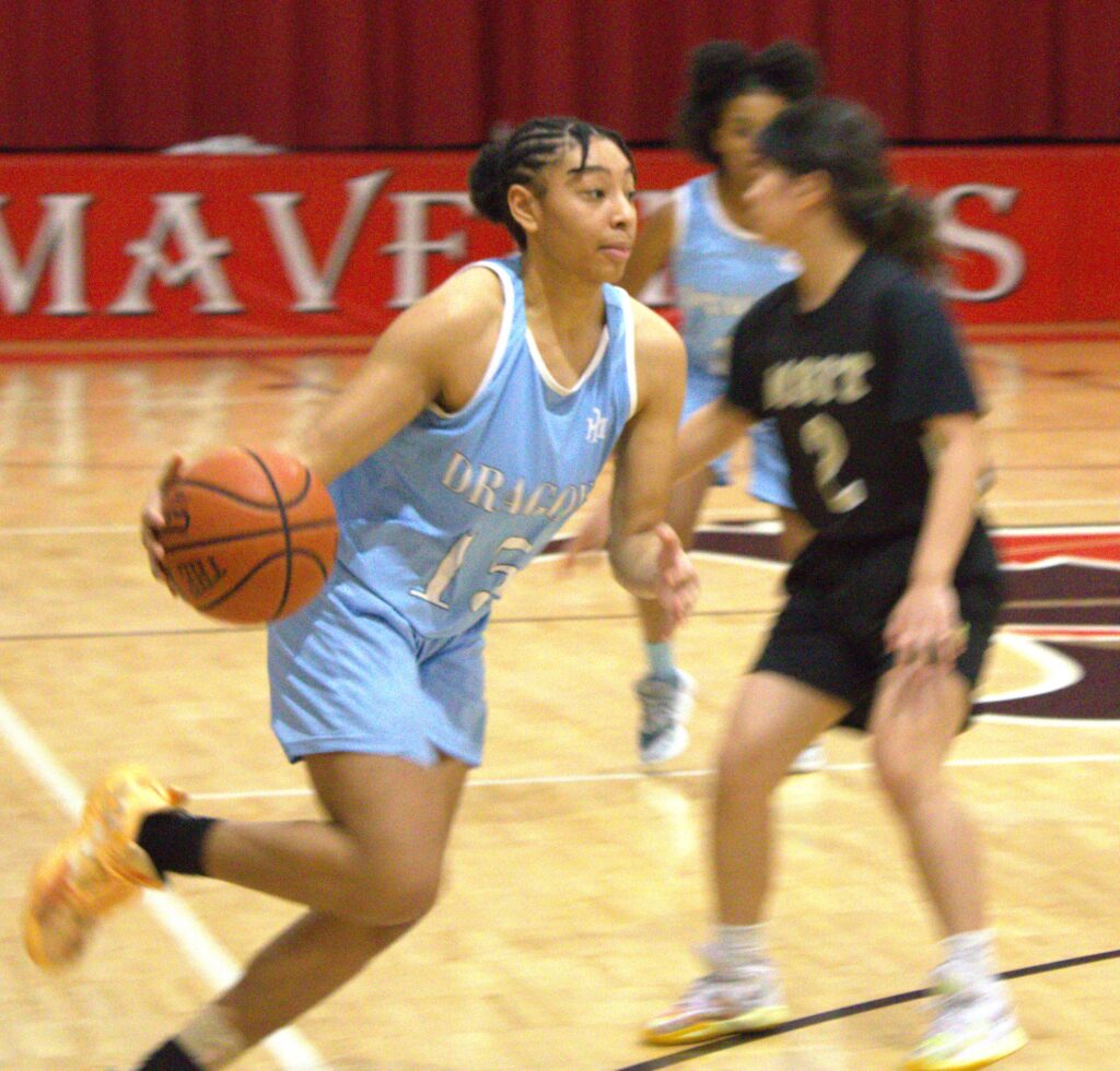 A girl is dribbling a basketball in the first round of the Borough President's Cup.