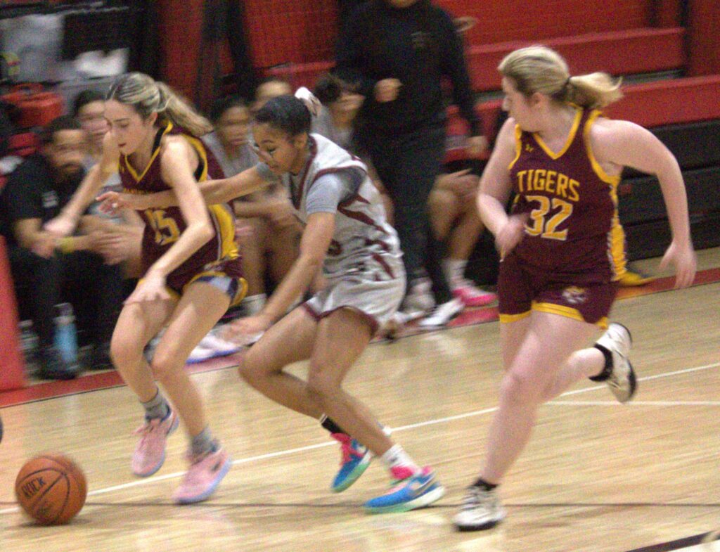 A group of girls competing against each other in the Borough President's Cup basketball tournament during the first round on a court.