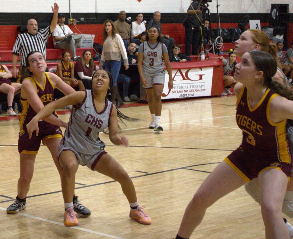 A group of girls competing in the first round of the Borough President's Cup basketball tournament on a court.