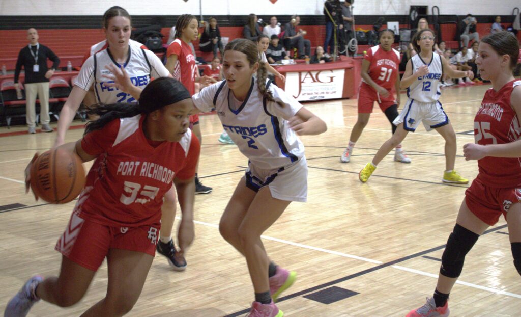 A group of girls competing in the first round of the Borough President's Cup basketball tournament on a court.