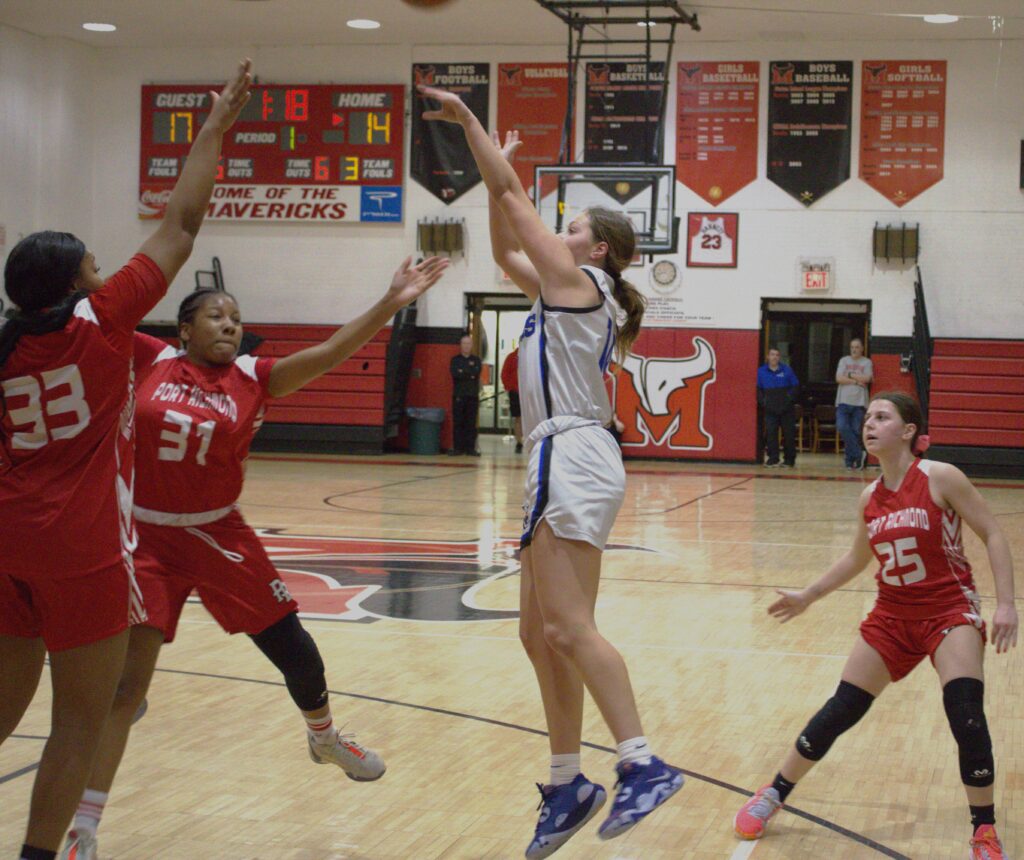 A team of girls competing in the first round of the Borough President's Cup basketball tournament at a gym.