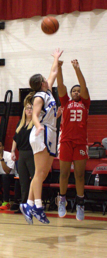 In the thrilling first round of the Borough President's Cup, a determined girl skillfully attempts to block a basketball.