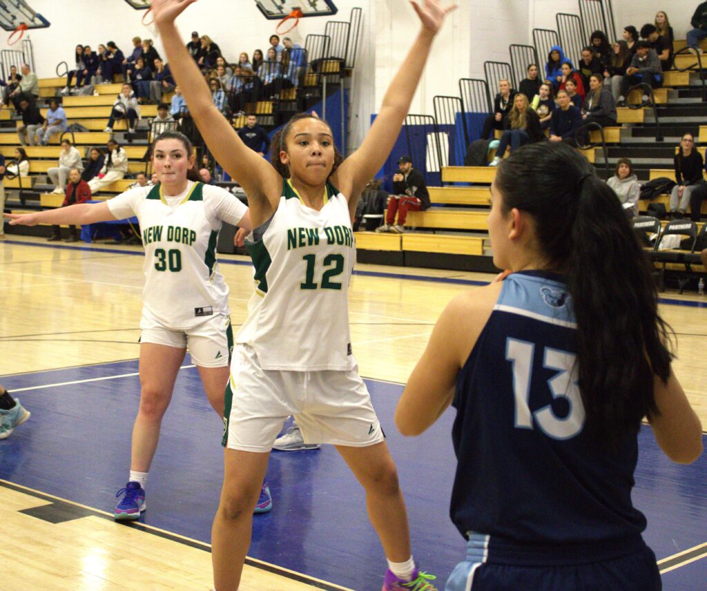 A group of girls playing basketball on a court, participating in a Tournament championship.