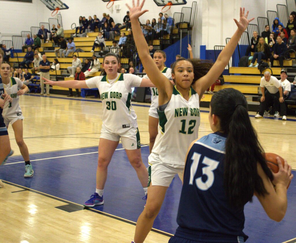 A group of girls competing in the girls' borough president tournament, dribbling and shooting hoops on a basketball court.