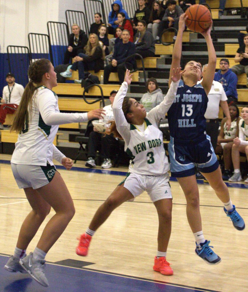 A group of girls playing basketball on a court, competing in the S.I. High School Girls' Borough President's Tournament championship.