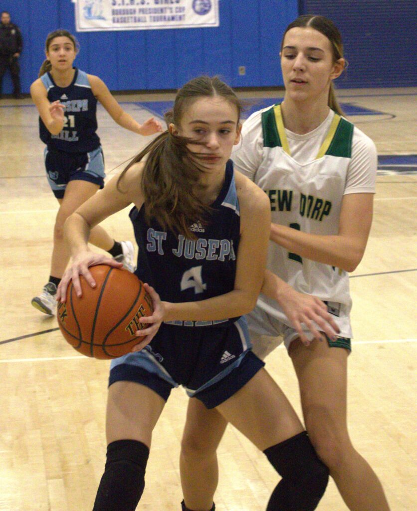 Two girls playing basketball on a court during the S.I. High School Girls' Borough President's Tournament.