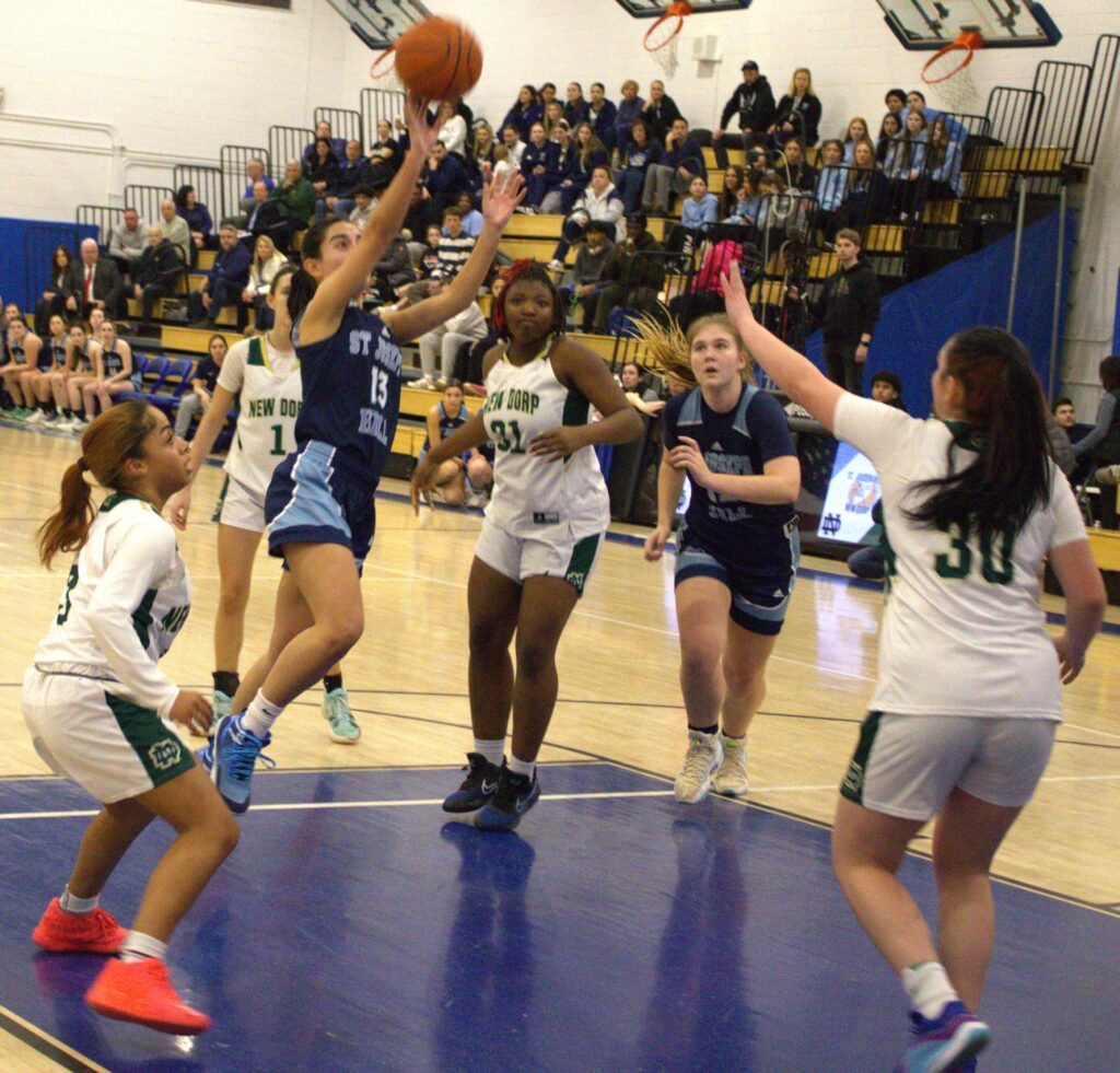 A group of girls playing basketball on a court at S.I. High School.