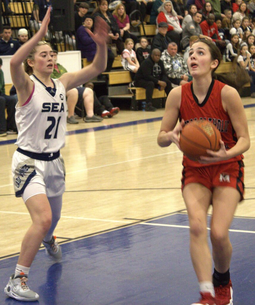 A group of high school girls playing basketball in the Borough President's Tournament championship.