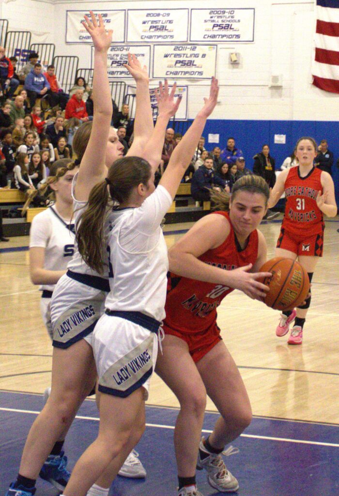 A group of girls playing basketball on the court at S.I. High School.