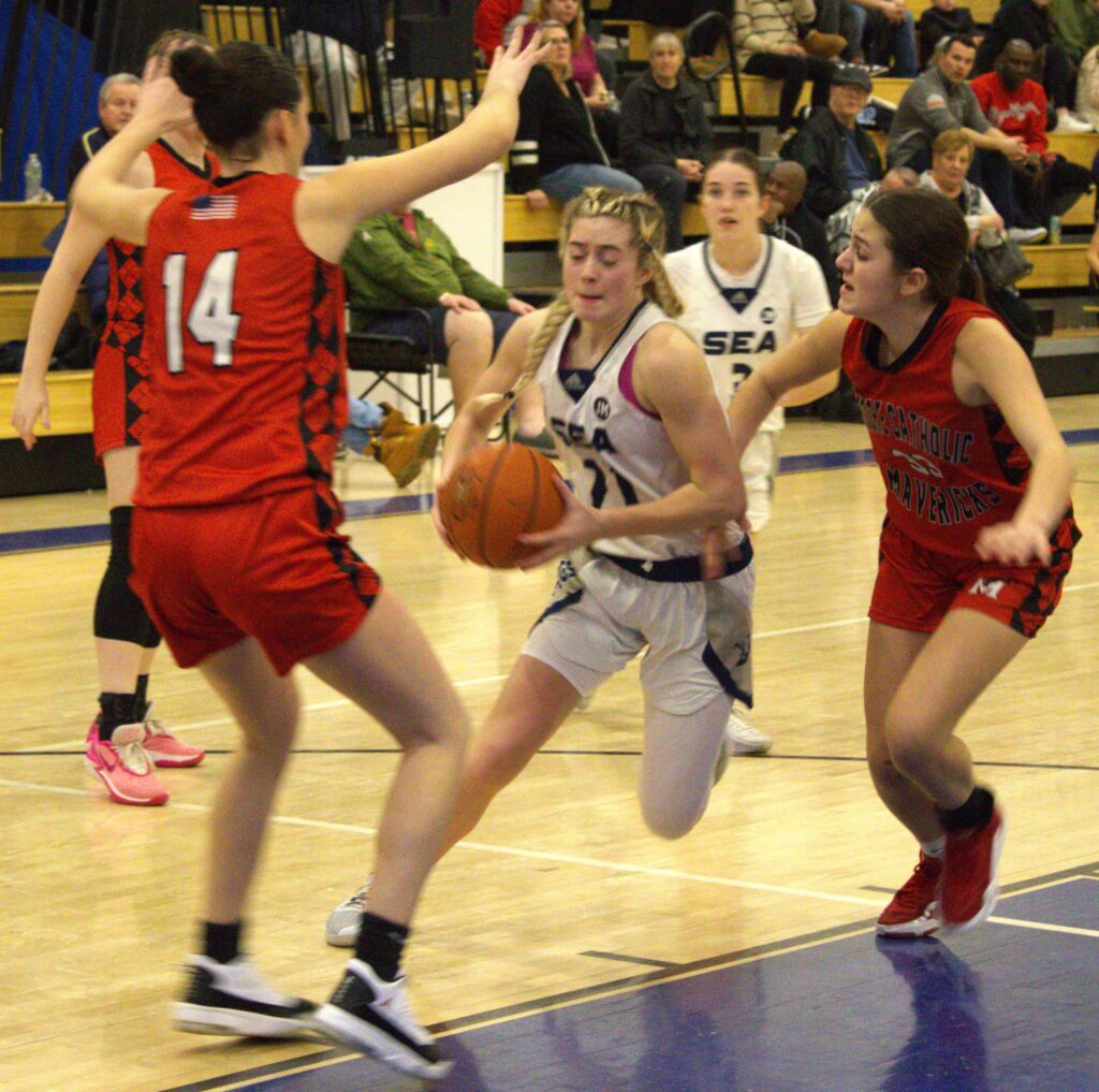 A group of high school girls playing basketball on a court.