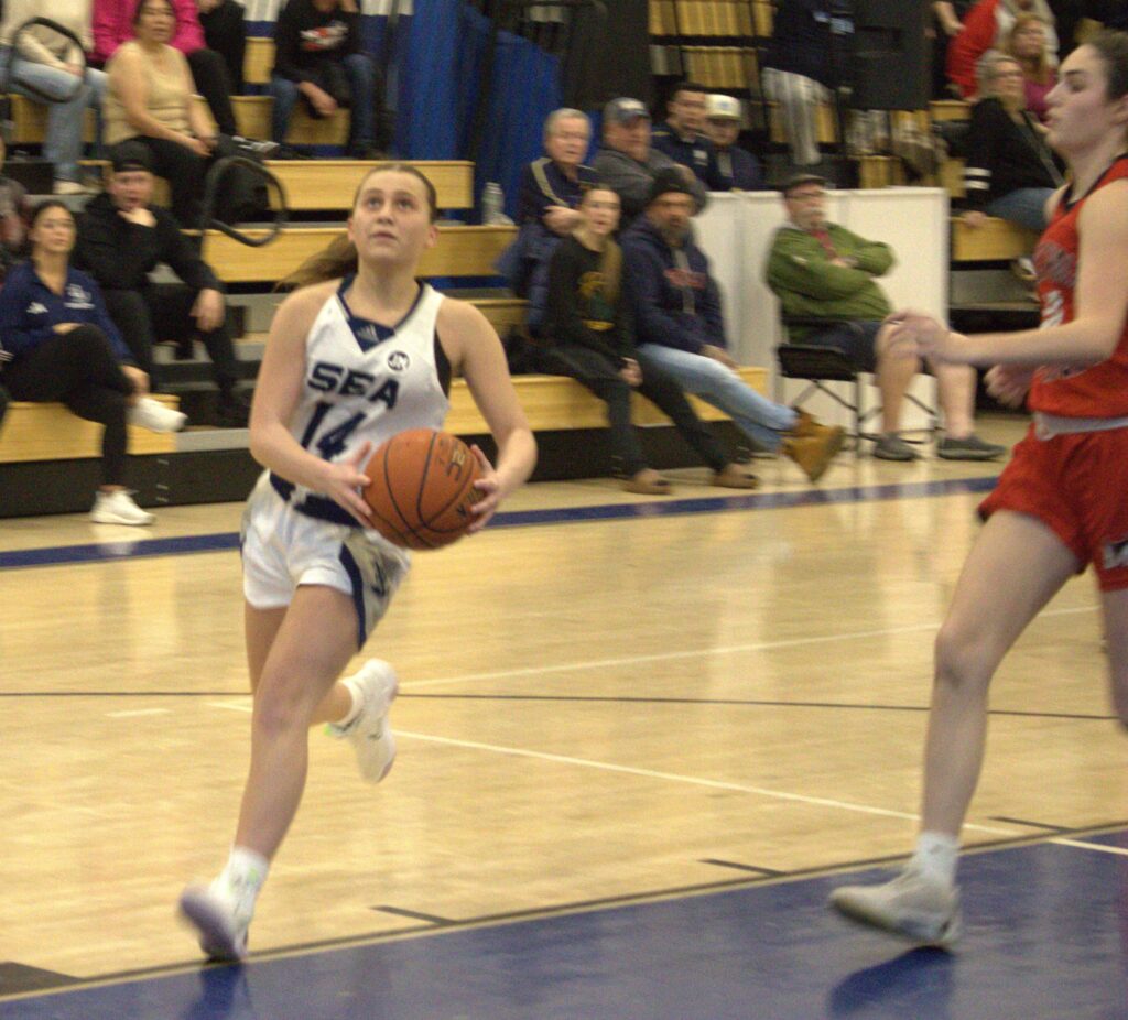 A girl is dribbling a basketball at the Girls' Borough.