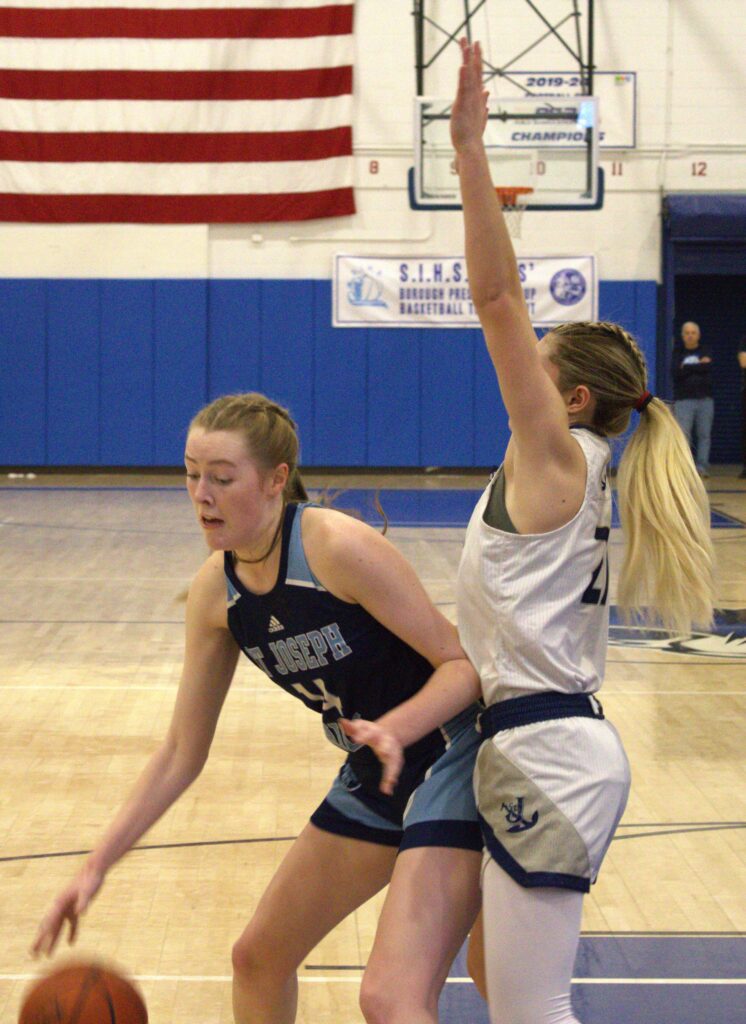 Two girls participating in the Borough President's Cup Tournament, playing basketball on a court.