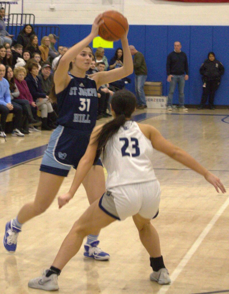 Two girls playing basketball on a court during the Borough President's Cup Tournament.