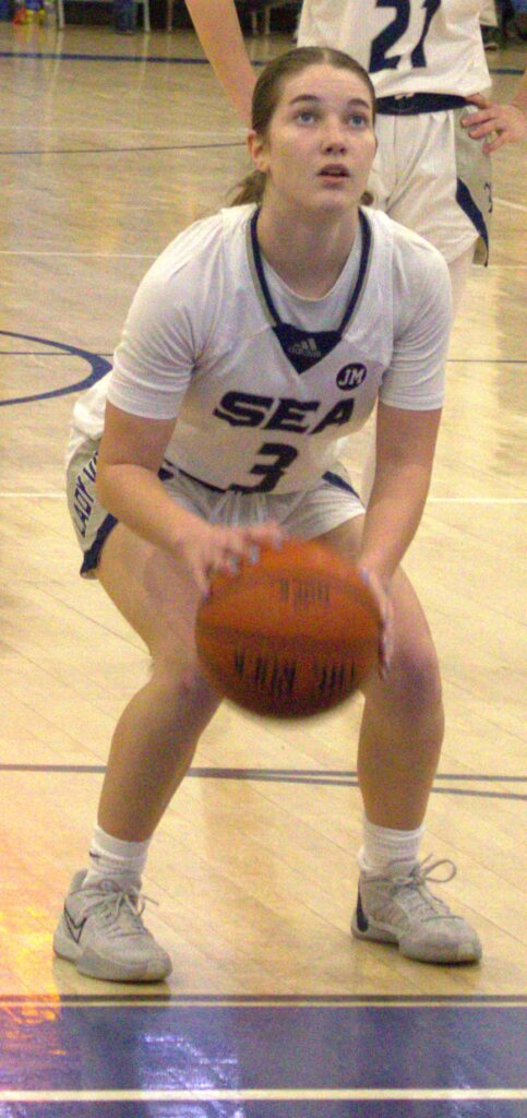 A woman holding a basketball participates in the Borough President's Cup Tournament at Sea.