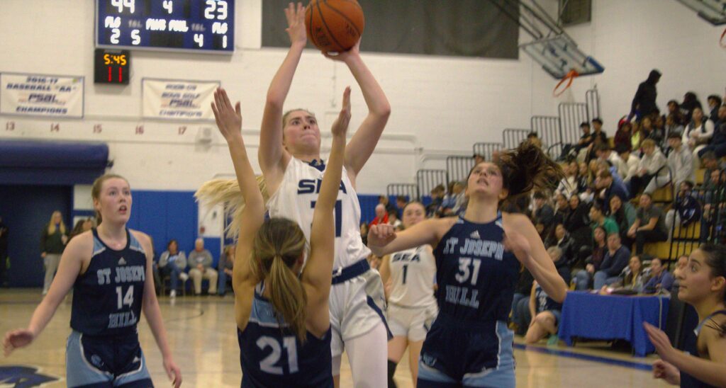 St. Joseph girls basketball players attempting to block a shot at the Borough President's Cup.