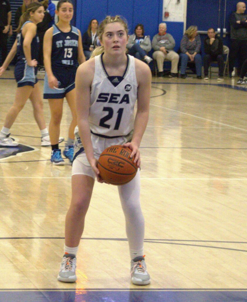 A girl participating in the Borough President's Cup Tournament, holding a basketball on a court.