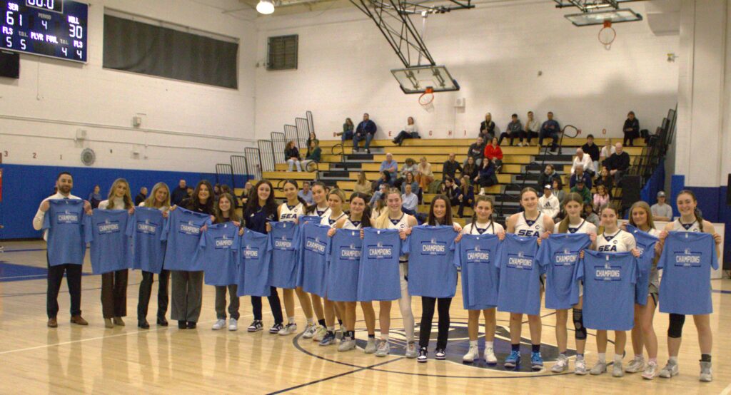 A group of girls posing in front of a basketball court during the Borough President's Cup Tournament.