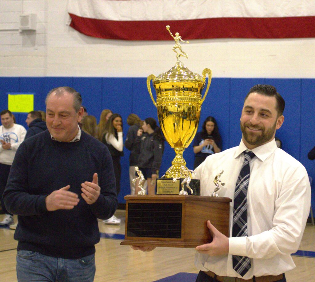 A man proudly displaying the St. Joseph trophy.