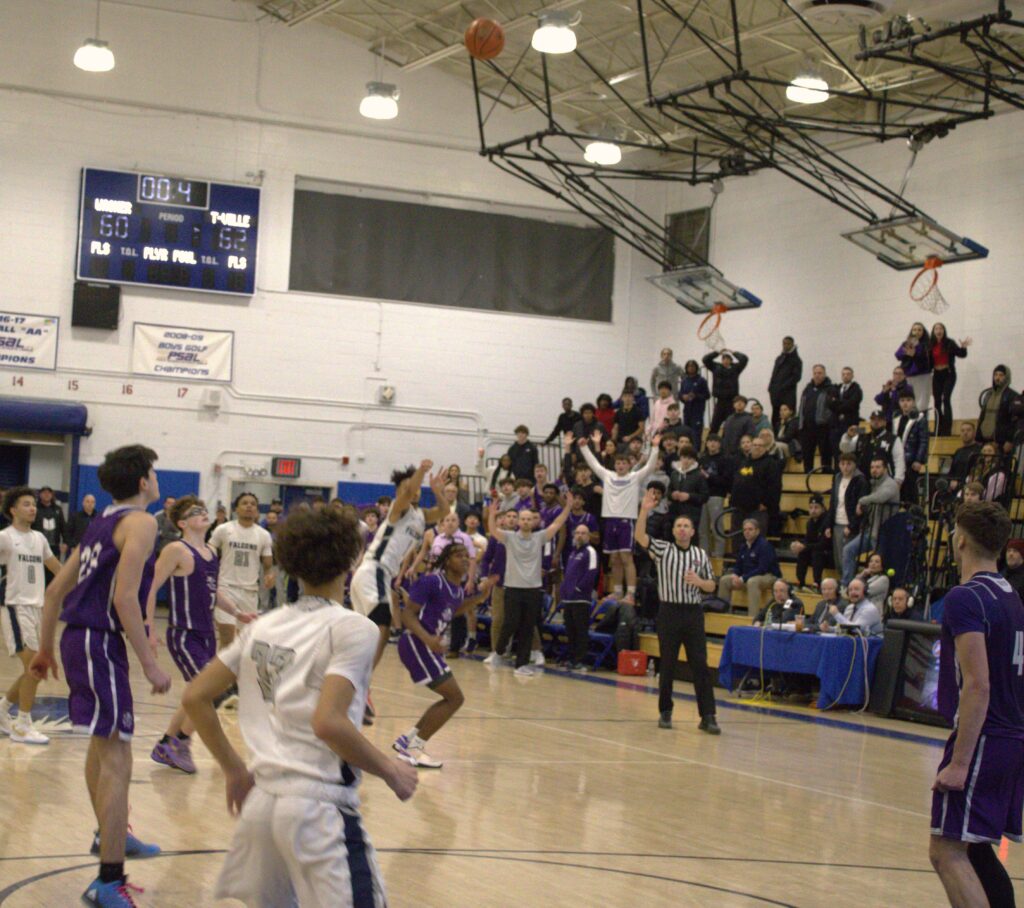 A group of people playing basketball at the SIHSL Tournament championship in Tottenville, with participation from St. Peters.