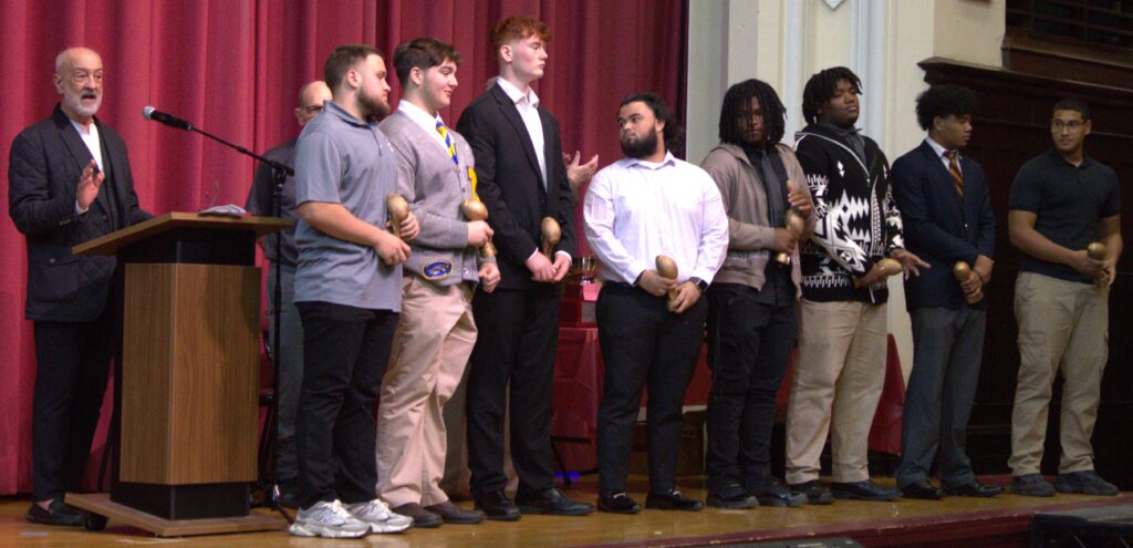 A group of men, including McBratney and Smith, standing on a stage holding awards.