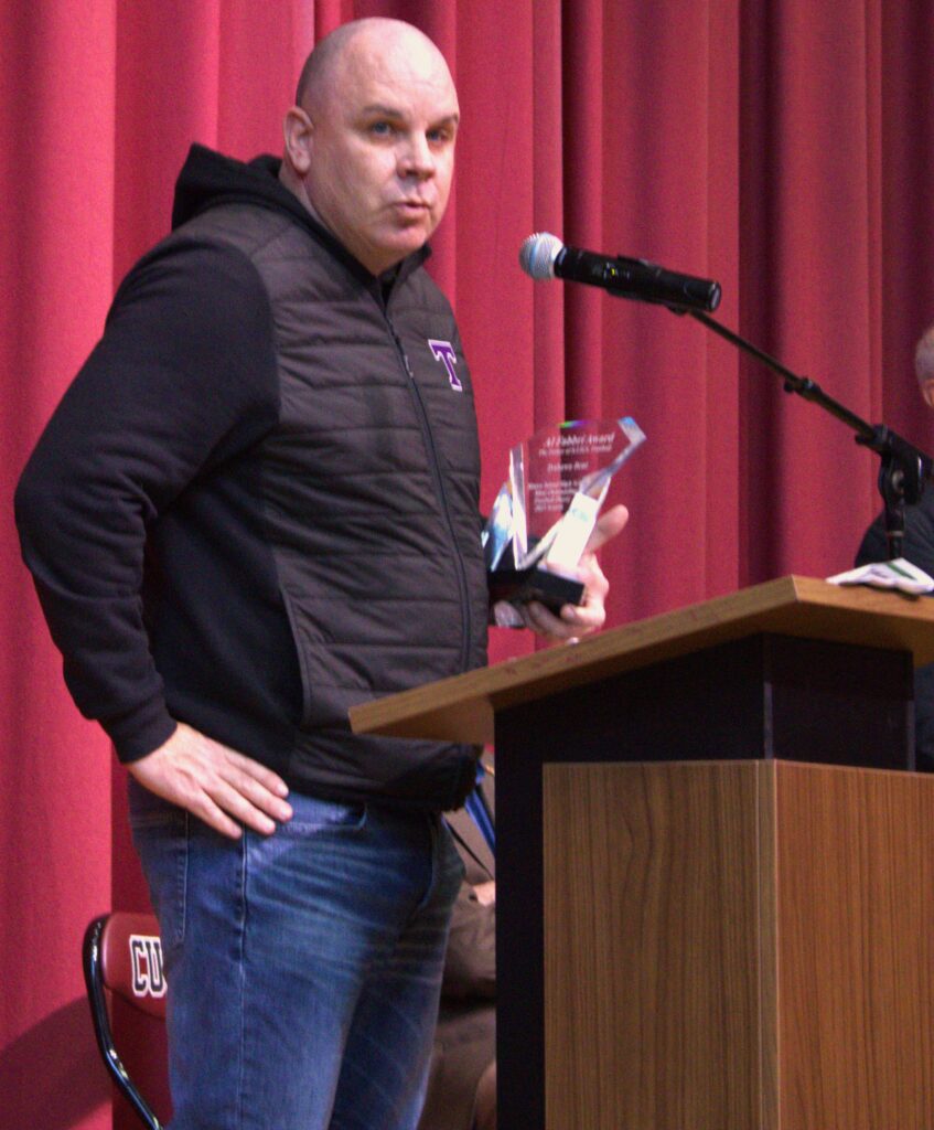 A man named Smith standing at a podium with a microphone.