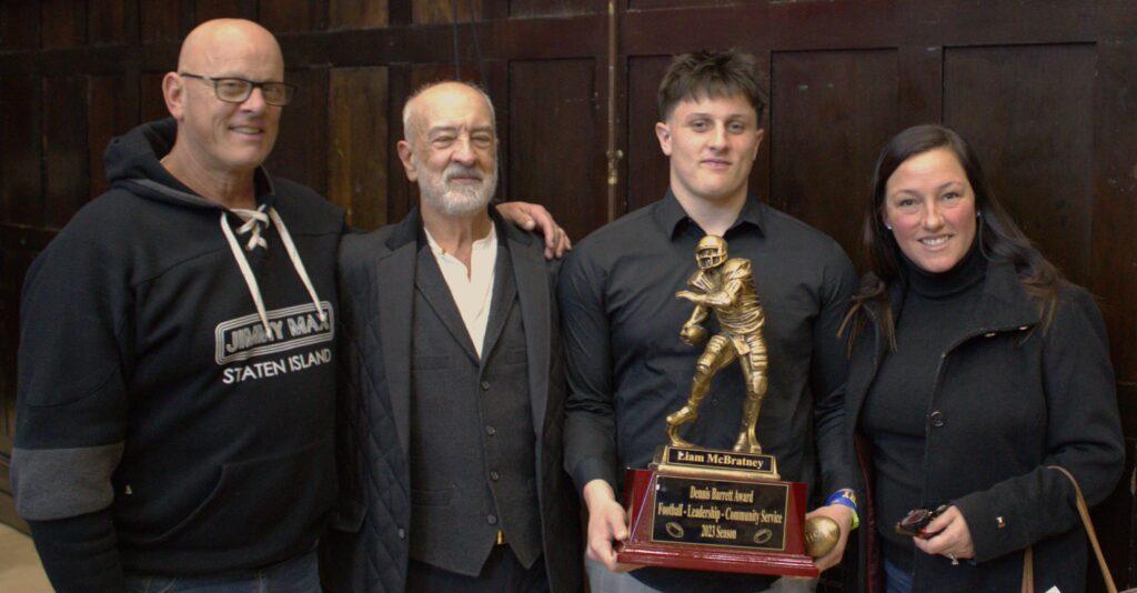 A group of men posing for a photo with an award.