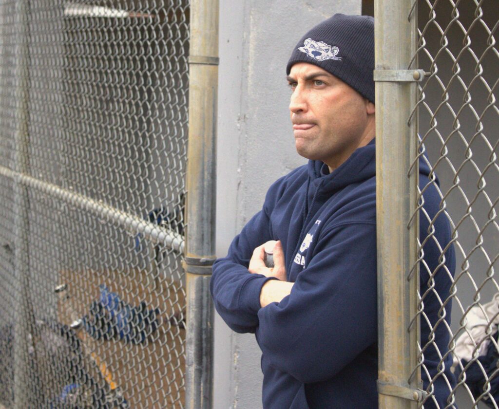 A man stands behind a chain link fence near St. Joseph's University.