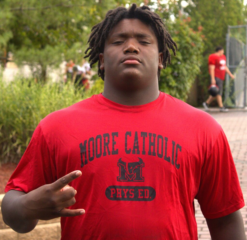 A young man from Staten Island wearing a red t-shirt.