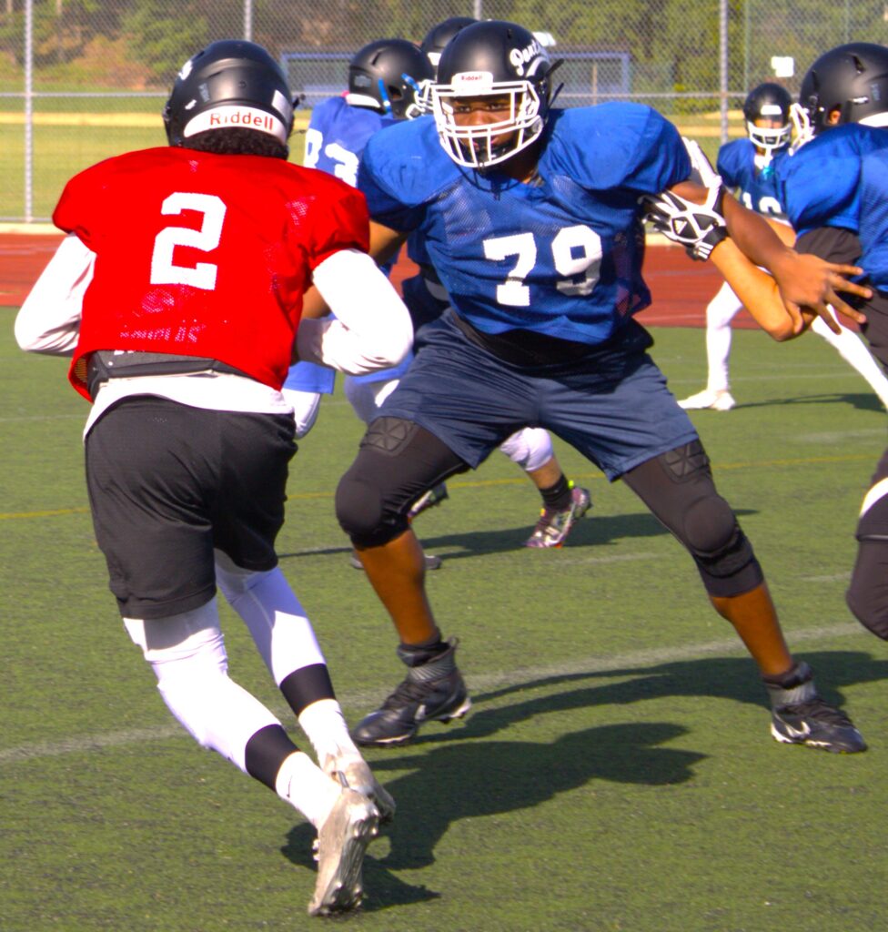 A group of high school football players on a field in Staten Island.