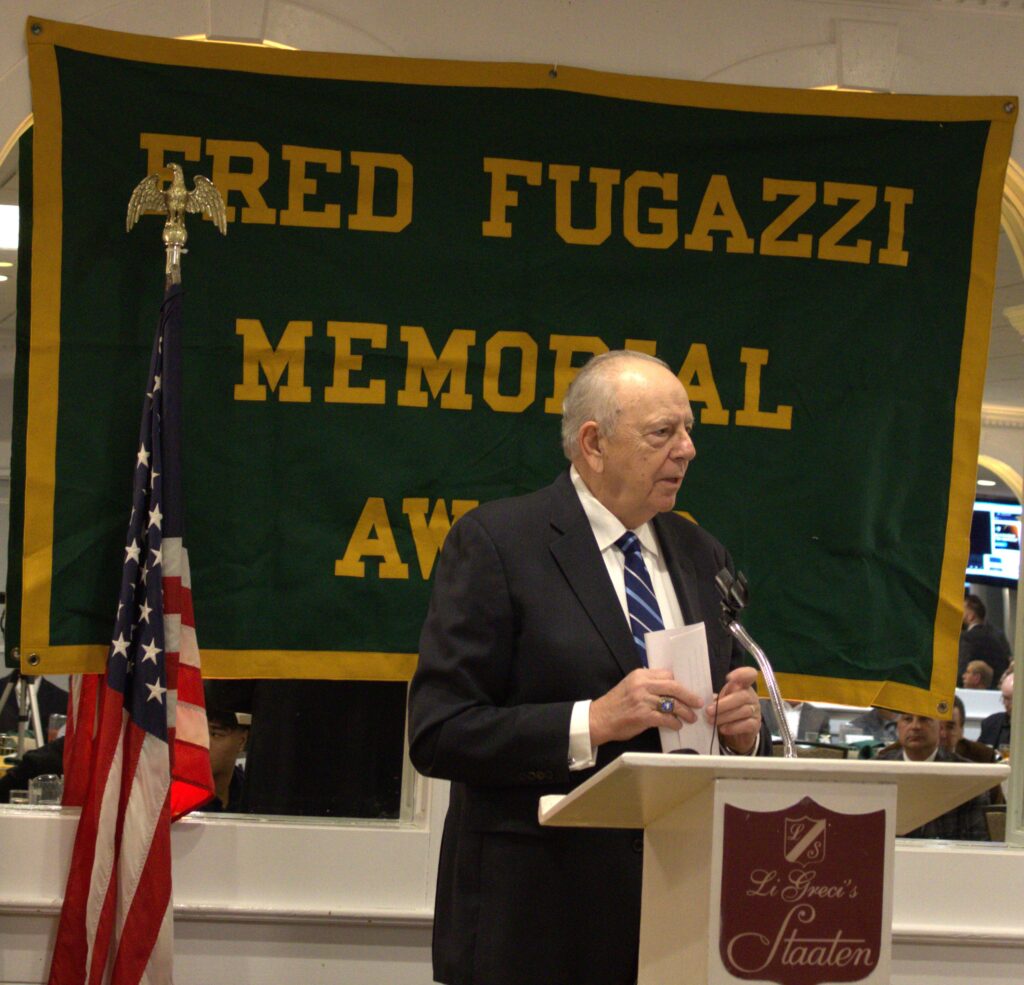 A man, possibly Fred Fugazzi, standing at a podium in Tottenville.