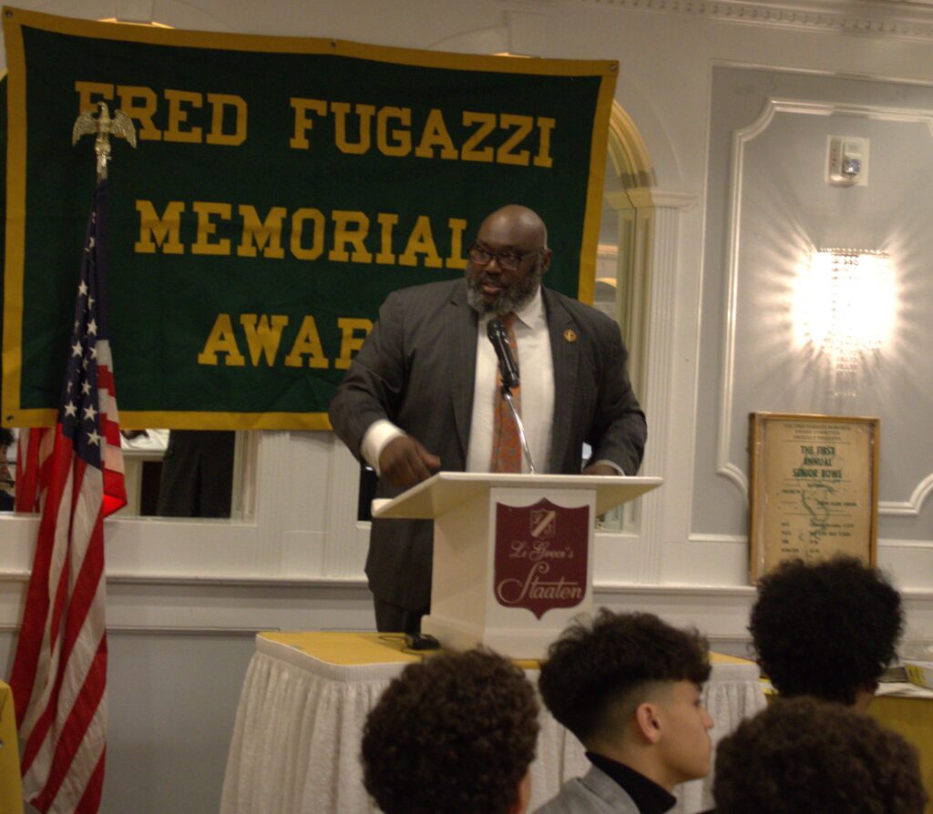 A man standing at a podium with a microphone is giving a speech.